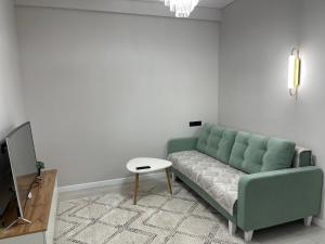 比什凯克Rent Apartment的客厅配有绿色沙发和桌子
