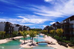 蒙舒瓦西Wonderful Mont Choisy flat, huge lagoon pool的棕榈树和建筑的度假游泳池
