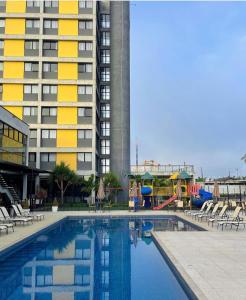佩尼亚Solar Pedra da Ilha - Quarto 611的大楼前带游乐场的游泳池