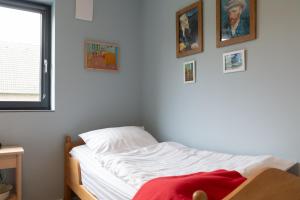 尼德根Fewo Eifel Eichen的墙上挂着照片的白色床