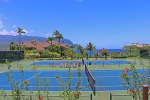 普林斯维尔Hanalei Bay Resort 2301 two的两个棕榈树和大海的网球场