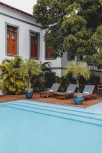 巴纳伊巴Casa de St. Antônio Hotel Boutique的一座房子旁的游泳池,配有两把躺椅