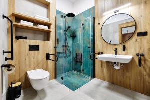 KonopnicaResort Zacisze Apartamenty的带淋浴、盥洗盆和镜子的浴室
