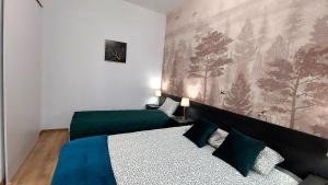 罗兹theApartments Gdańska的一间卧室设有两张床,墙上挂着一幅画