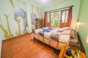 提喀迪Chrissie's Hotel的一间卧室配有一张床和一张大象壁画