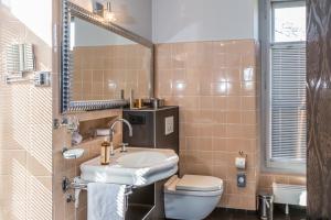 莫尔日伊戈尔宅邸酒店的一间带水槽、卫生间和镜子的浴室