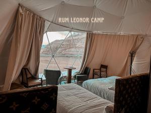 瓦迪拉姆RUM LEONOR CAMP的帐篷配有两张床和一张桌子及椅子