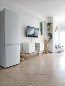 卡拉德费斯特拉特Apartamento, La Cala Vicent&Alba的一间带电视和白色冰箱的客厅