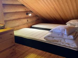 阿卡斯洛姆波罗Ruska 2, Ylläs - Hirsimökki järvi- ja tunturimaisemilla的配有木天花板的客房内的两张床