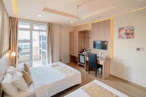 胡鲁马累三间客栈的酒店客房配有一张床、一张书桌和一台电视。