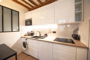 巴黎Appartement cosy Montorgueil (Bonne Nouvelle)的厨房配有白色橱柜和水槽
