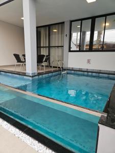 帕拉蒂Villa da Serra 2 - Casa com piscinas privativas vidro的大楼内的一个蓝色海水游泳池