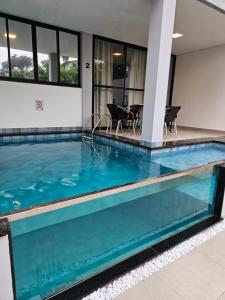 帕拉蒂Villa da Serra 2 - Casa com piscinas privativas vidro的大楼内的一个蓝色海水游泳池