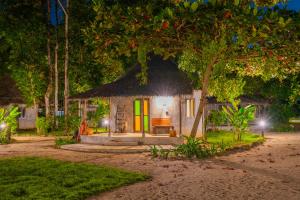 象岛The Tropical Beach Resort的树下茅草屋顶的小小屋