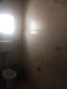 拉穆Yaye House的浴室配有卫生间和墙上的灯。