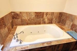 斯旺顿Lane's End near Deep Creek Lake的浴室设有棕色瓷砖,配有大型白色浴缸。