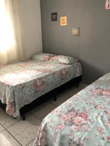 瓜鲁雅Kitnet do Costa Praia do Pereque Guaruja!!!的一间客房内配有两张床的房间