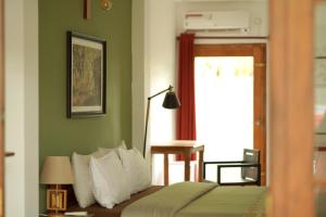 韦利格默Temple Tree的一间卧室配有一张带绿色墙壁的床