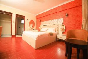 纳库鲁Gold Suite Hotel的卧室配有白色的床和红砖墙