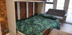 SouthwickTiny home whole flat beach cabin的一间卧室配有绿色的床和沙发