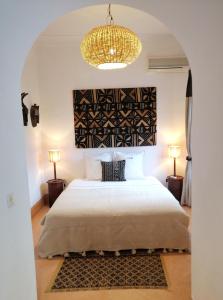 马拉喀什达尔努巴摩洛哥传统庭院住宅的一间卧室配有一张大床和一个吊灯。