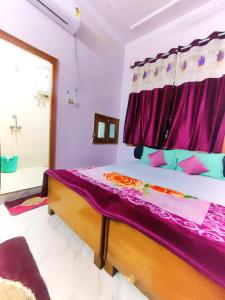 克久拉霍Hostel shivshakti khajuraho的一间卧室配有一张带紫色床单的床和窗户。