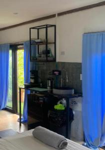TorioSea view hills bungalow的一间带水槽和蓝色窗帘的浴室