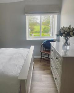 SimonsbathWinstitchen Cottage的一间卧室配有一张床和一张带花瓶的书桌