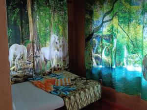 ChegātKalidasa Tree House and Villa, Wayanad的墙上装饰着独角兽画的房间