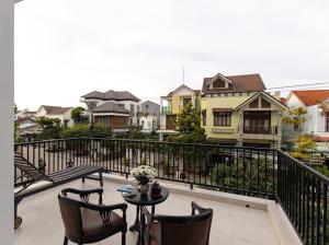 会安Simon House Hoi An的阳台配有桌椅和房屋。