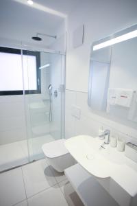 洛迦诺Hotel Bellavista Locarno的白色的浴室设有水槽和淋浴。