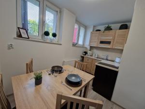 萨诺克Apartament w Śródmieściu的一间带木桌的厨房和一间餐厅