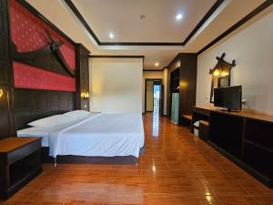 芭东海滩Nanai 2 Residence Patong Phuket的一间卧室配有一张床和一台平面电视