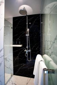 曼谷SAM E Hotel Bangkok Sathorn的带淋浴和黑色大理石墙的浴室