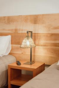 科伊艾科PURA Hotel的一张木桌旁的灯,床旁边是一张