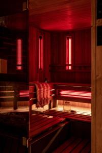 新塔尔格OBERŻA POD RÓŻĄ restauracja, sauny, jacuzzi的一间空房间,有红色的灯光和长凳