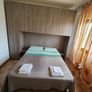 塞尔莫内塔Appartamento Oasi di Pontenuovo的房间里的一张床位,上面有两条毛巾