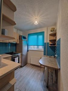 里加Iļģuciema Apartment的厨房配有桌子和蓝色窗户。