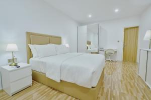 KamadhooAkomadoo Retreat的卧室配有一张白色大床和镜子
