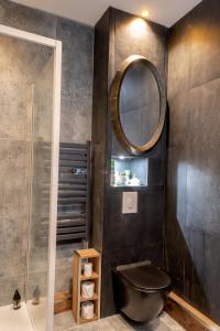 勒米尔蒙LA BELL'CHAPELLE的浴室设有黑色的卫生间和镜子