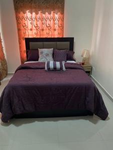 Okunola3 Bedroom Spacious Apartment的一间卧室配有一张大床和紫色棉被