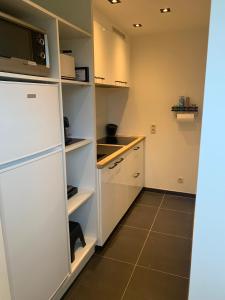 HerzeleQ Guesthouse的厨房配有白色橱柜和白色冰箱。