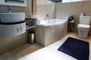布隆方丹Yellow Door的带浴缸、盥洗盆和卫生间的浴室