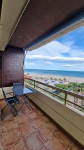 波多黎多德萨贡托Vistas espectaculares 1ª linea playa, WIFI, ASCENSOR的阳台配有桌子,享有海滩美景