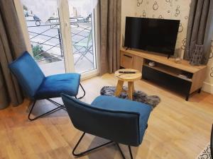 尚帕尼奥勒Maison de ville 70m²的客厅配有两把椅子和电视