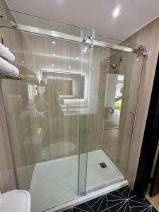 斯坦顿Casa Playa Inn & Suites Stanton Anaheim Area的浴室里设有玻璃门淋浴