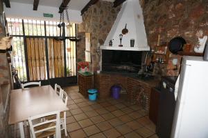 奥萨德蒙铁尔Casa Rural Noel en Parque Natural Lagunas de Ruidera的厨房配有壁炉和桌椅。