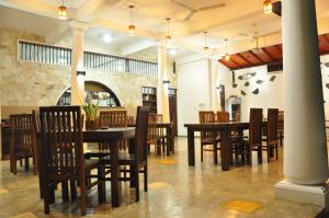 乌纳瓦图纳堡垒边缘休闲酒店的用餐室配有木桌和椅子