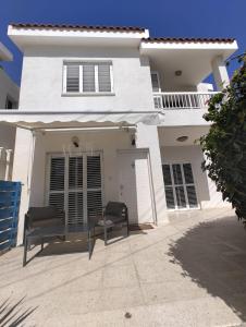 帕福斯Kato Paphos 2 Bedroom House - Tourist location的前面有两把椅子的白色房子