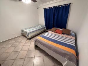 孔塔多拉Villa Rehobot的一间卧室配有两张床和蓝色窗帘